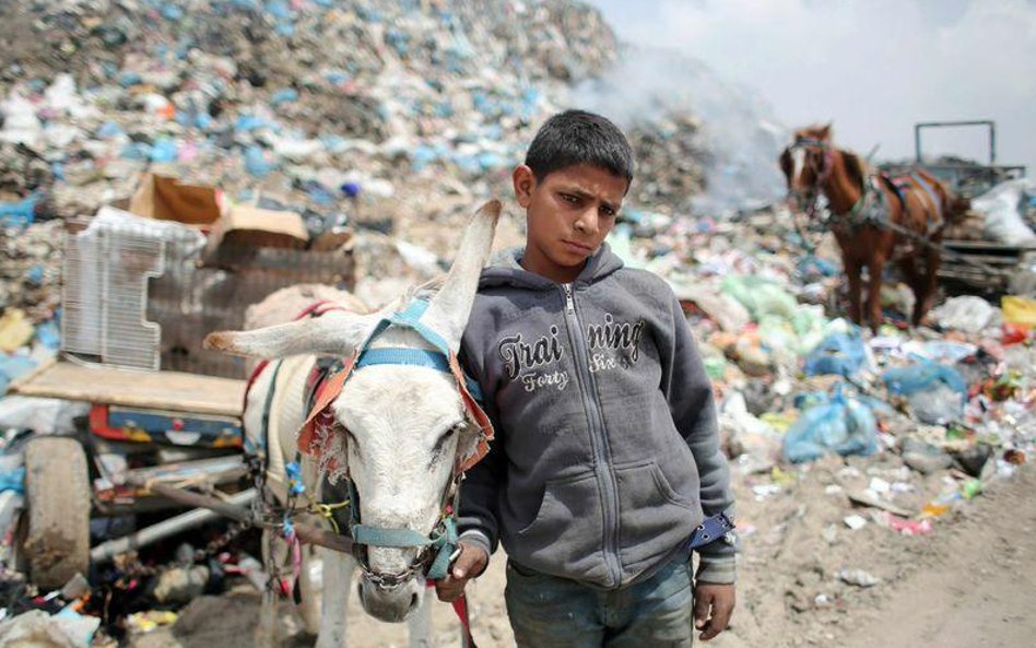 Młody Palestyńczyk pracuje na wysypisku śmieci w pobliżu Rafah, w południowej części Strefy Gazy