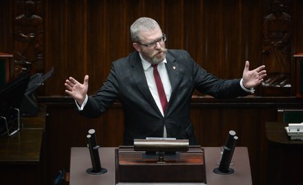 Poseł Grzegorz Braun na mównicy sejmowej po tym jak zgasił gaśnicą sejmowe świece chanukowe zapalone