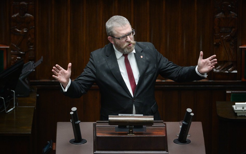 Poseł Grzegorz Braun na mównicy sejmowej po tym jak zgasił gaśnicą sejmowe świece chanukowe zapalone