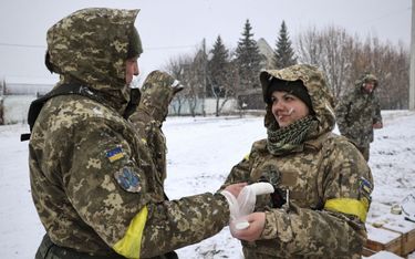 Ukraiński żołnierz opatrywany przez sanitariuszkę