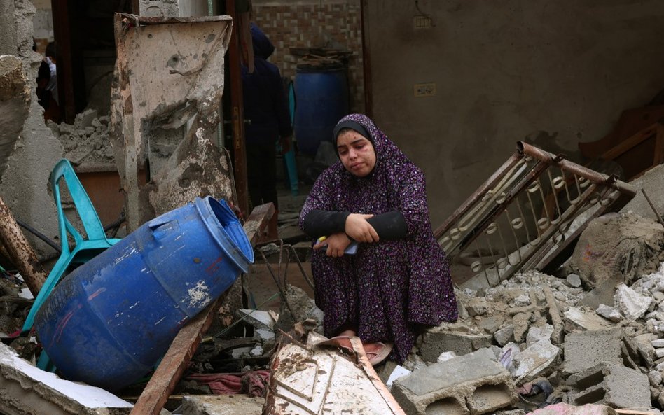 Kobieta na gruzach budynku zniszczonego w wyniku izraelskiego bombardowania w Rafah w południowej St