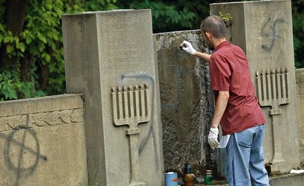 Licealiści sprzątają cmentarz żydowski w Częstochowie w 2007 r. Zmywają nazistowskie symbole namalow