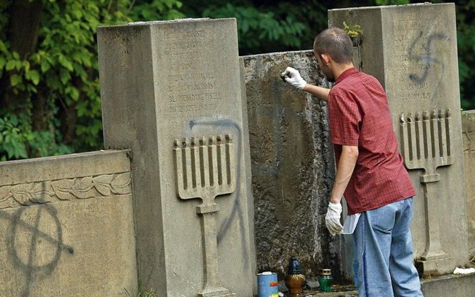 Licealiści sprzątają cmentarz żydowski w Częstochowie w 2007 r. Zmywają nazistowskie symbole namalow