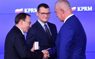 Mariusz Kamiński i Paweł Szefernaker (w środku) odznaczają Odznaką Honorową za Zasługi dla Samorządu