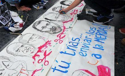 Protestujący na placu Katalońskim w Barcelonie malują karykatury czołowych hiszpańskich polityków