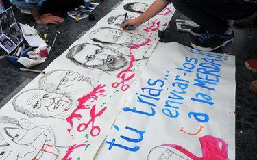 Protestujący na placu Katalońskim w Barcelonie malują karykatury czołowych hiszpańskich polityków