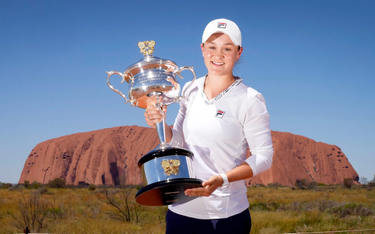 Ashleigh Barty z nagrodą za zwycięstwo w Australian Open 2022 na tle Uluru – świętej góry Aborygenów