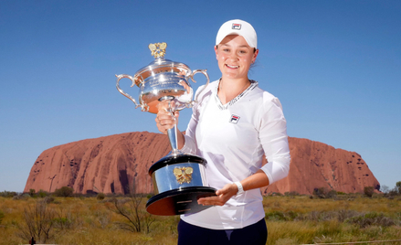 Ashleigh Barty z nagrodą za zwycięstwo w Australian Open 2022 na tle Uluru – świętej góry Aborygenów