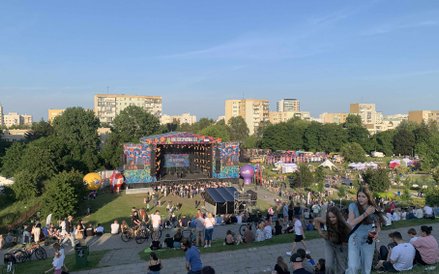 Szeroka perspektywa z Kopy Cwila na cały teren festiwalu. Widać główną scenę, stoiska i setki osób, 