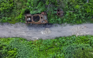 Zdjęcie wykonane dronem przedstawia zniszczony czołg w pobliżu drogi we wsi Dowheńke w obwodzie char