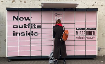 Kobieta stoi przy skrzynce InPost w Hackney w Londynie.