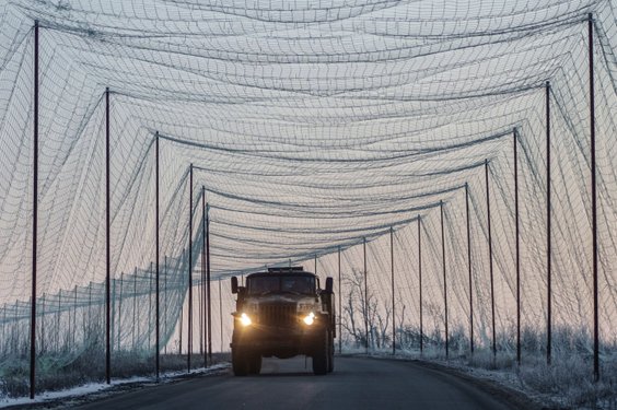 Ciężarówka wojskowa na drodze zabezpieczonej siatką antydronową, fotografia z 21 stycznia wykonana w