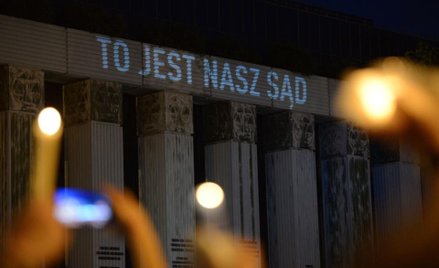 Protestujący z płonącymi świecami przed siedzibą SN