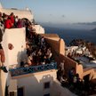 Turyści oglądający zachód słońca w mieście Oia na wyspie Santorini