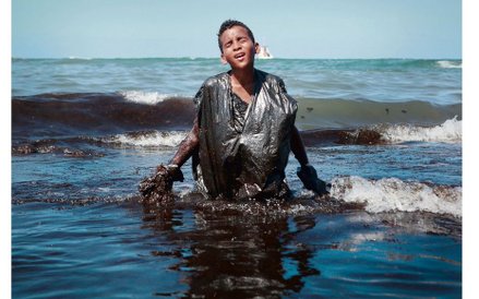 Chłopiec wychodzi z morza podczas usuwania plamy ropy na plaży Itapuama niedaleko Cabo de Santo Agos