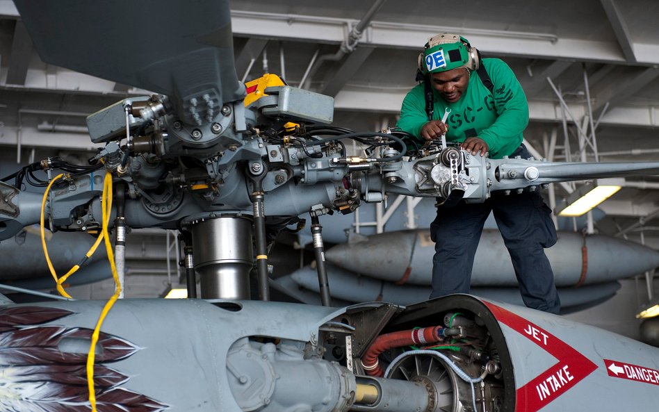 Mechanik pokładowy podczas prac serwisowych przy głowicy wirnika głównego śmigłowca MH-60S Seahawk w