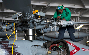 Mechanik pokładowy podczas prac serwisowych przy głowicy wirnika głównego śmigłowca MH-60S Seahawk w