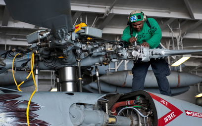 Mechanik pokładowy podczas prac serwisowych przy głowicy wirnika głównego śmigłowca MH-60S Seahawk w