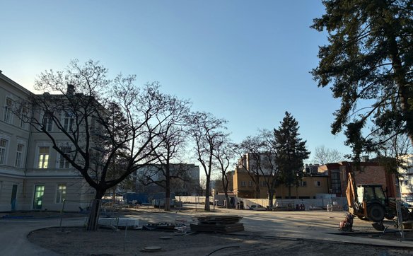 Zdjęcia przedstawiające rozległy, pusty plac z kontenerami i materiałami budowlanymi to miejsce, gdz