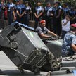 Policjanci i pracownicy służb miejskich rozbierają barykadę z pojemnikó na śmieci w Erewaniu