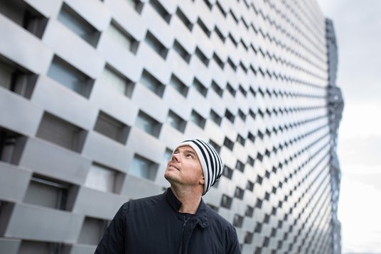 Architekt Bjarke Ingels na tle budynku zaprojektowanego przez jego firmę.