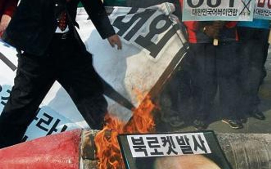 Demonstranci w Seulu spalili portrety Kim Dzong Ila i miniaturowe modele rakiety na wiecu zorganizow