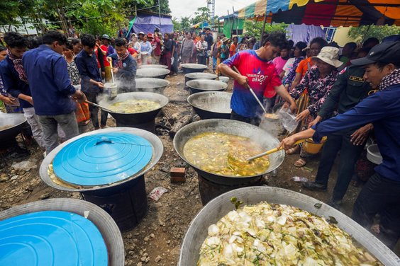 Ewakuowani mieszkańcy kambodżańskiej wioski ustawiają się w kolejce po posiłek w miejscu tymczasoweg