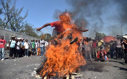 19 stycznia, Port-au-Prince. Mężczyzna skacze przez ogień w trakcie protestów przeciwko fałszowaniu 