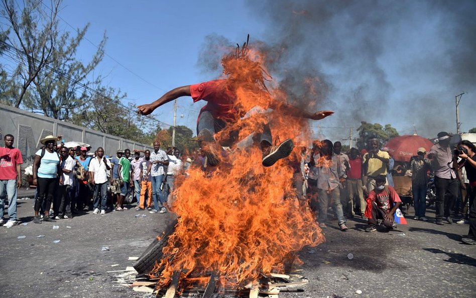 19 stycznia, Port-au-Prince. Mężczyzna skacze przez ogień w trakcie protestów przeciwko fałszowaniu 