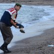 Turecki policjant podnosi ciało trzyletniego Aylana Kurdi na wybrzeżu Bodrum