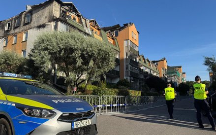 Policjanci przed spalonym budynkiem w Ząbkach