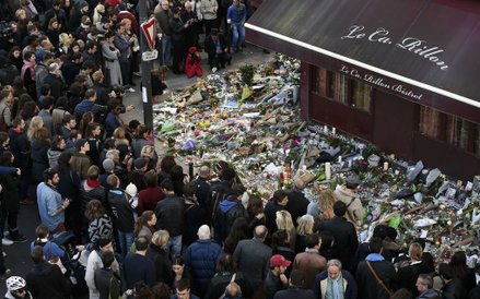 15 listopada, Paryż. Ludzie zgromadzeni przed restauracją Carillion składają hołd ofiarom ataku terr