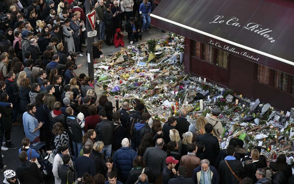 15 listopada, Paryż. Ludzie zgromadzeni przed restauracją Carillion składają hołd ofiarom ataku terr