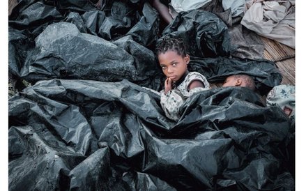 Enia Joaquin Luis (11 lat) budzi się obok siostry Luisy (6 lat) pod przykryciem z plastikowych workó