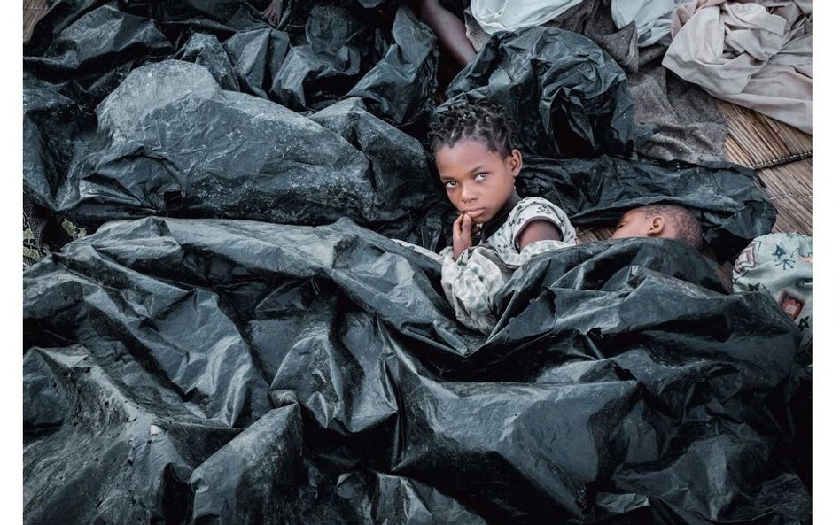 Enia Joaquin Luis (11 lat) budzi się obok siostry Luisy (6 lat) pod przykryciem z plastikowych workó