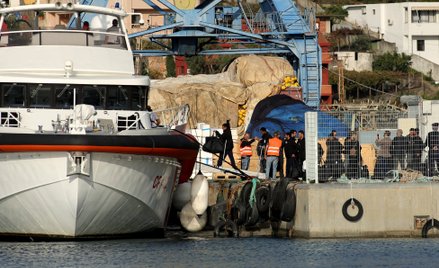 Grupa migrantów wchodzi na pokład włoskiego statku straży przybrzeżnej w porcie Shengjin w Albanii