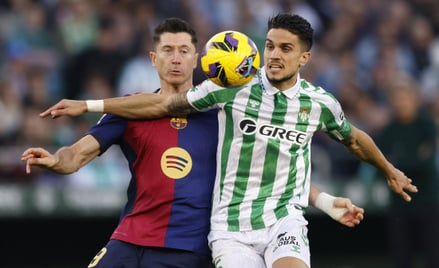 Robert Lewandowski i Marc Bartra w walce o piłkę podczas meczu Real Betis - FC Barcelona