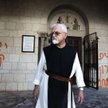 Zakonnik przed klasztorem Latrun. Po lewej hebrajski napis „Jezus to małpa”