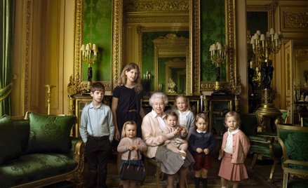 Królowa Elżbieta w otoczeniu wnucząt i prawnucząt w jednej z komnat zamku Windsor.