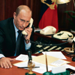 Władimir Putin za biurkiem męża stanu. Telefony w kolorze écru, mikrofony, przyciski. A teczka z kod