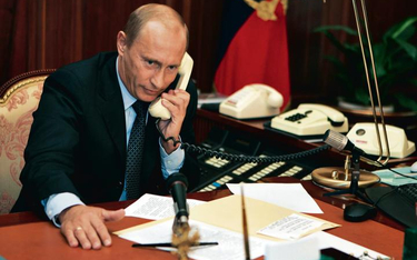 Władimir Putin za biurkiem męża stanu. Telefony w kolorze écru, mikrofony, przyciski. A teczka z kod