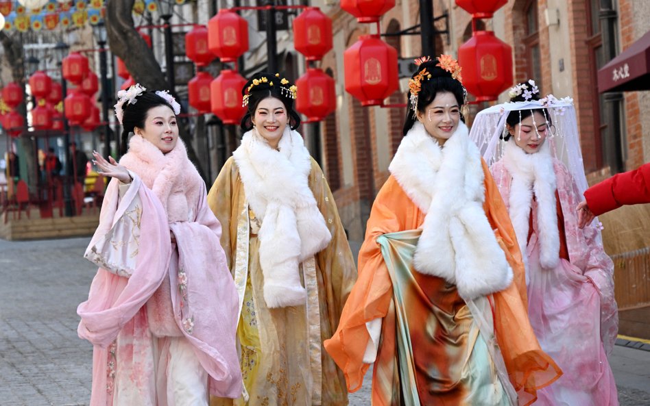 Kobiety ubrane w tradycyjne chińskie stroje spacerują ulicą w Qingdao, w prowincji Shandong we wscho