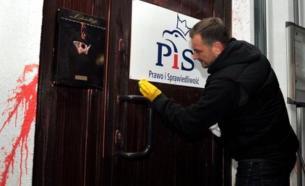 Poseł PO Sławomir Nitras zmywa farbę z drzwi biura PiS w Szczecinie