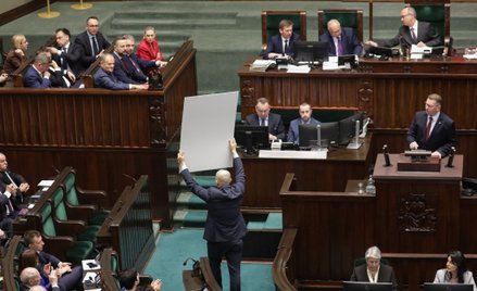 Posłowie PiS z banerami na sali plenarnej Sejmu
