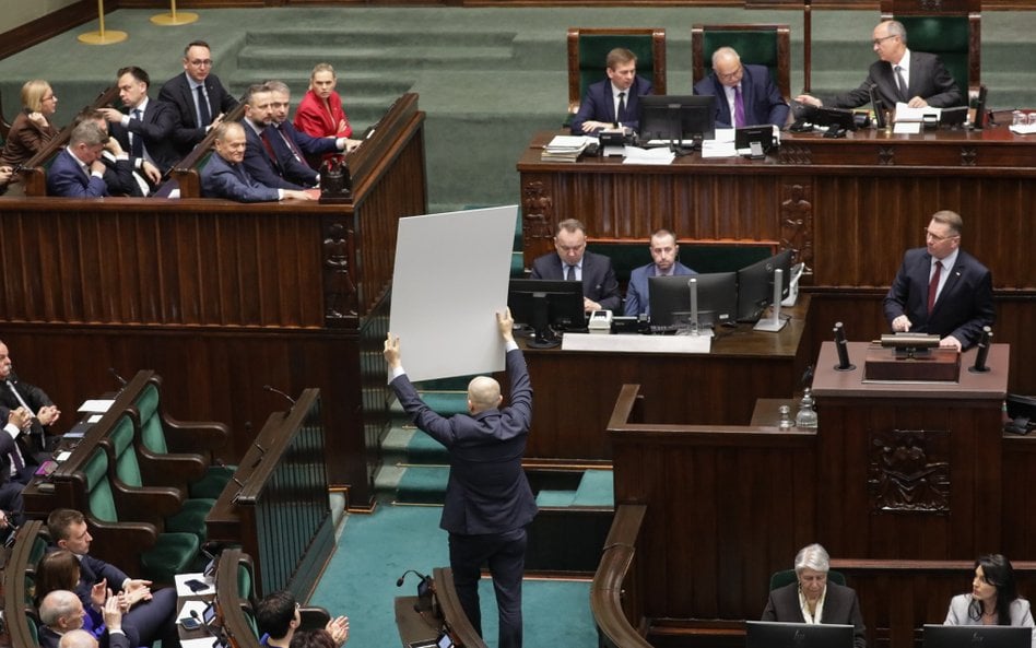Posłowie PiS z banerami na sali plenarnej Sejmu