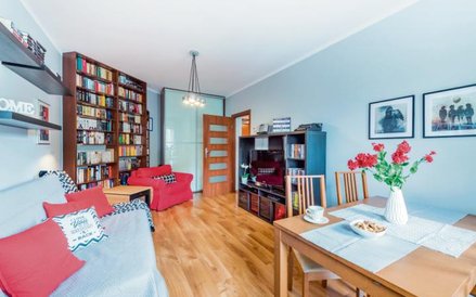 Home stager zadba o odpowiednie dodatki: poduszki, obrazy, kwiaty, słodycze na stole.