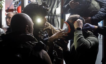Ratownicy zakładają maskę rannemu po rosyjskim ataku rakietowym na budynek mieszkalny w Kijowie. Zda