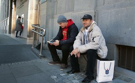 Kurierzy wysłani przez przedsiębiorców z wnioskami o dotacje czekają przed bankiem