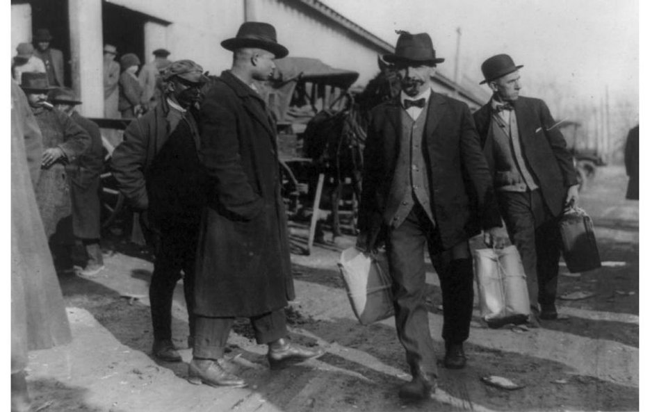 Dwóch mężczyzn z amerykańskiego Urzędu Skarbowego niosących paczki skonfiskowanego alkoholu