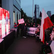 Zwolennicy kandydatów oglądają debatę na telebimie przed siedzibą TV Republika